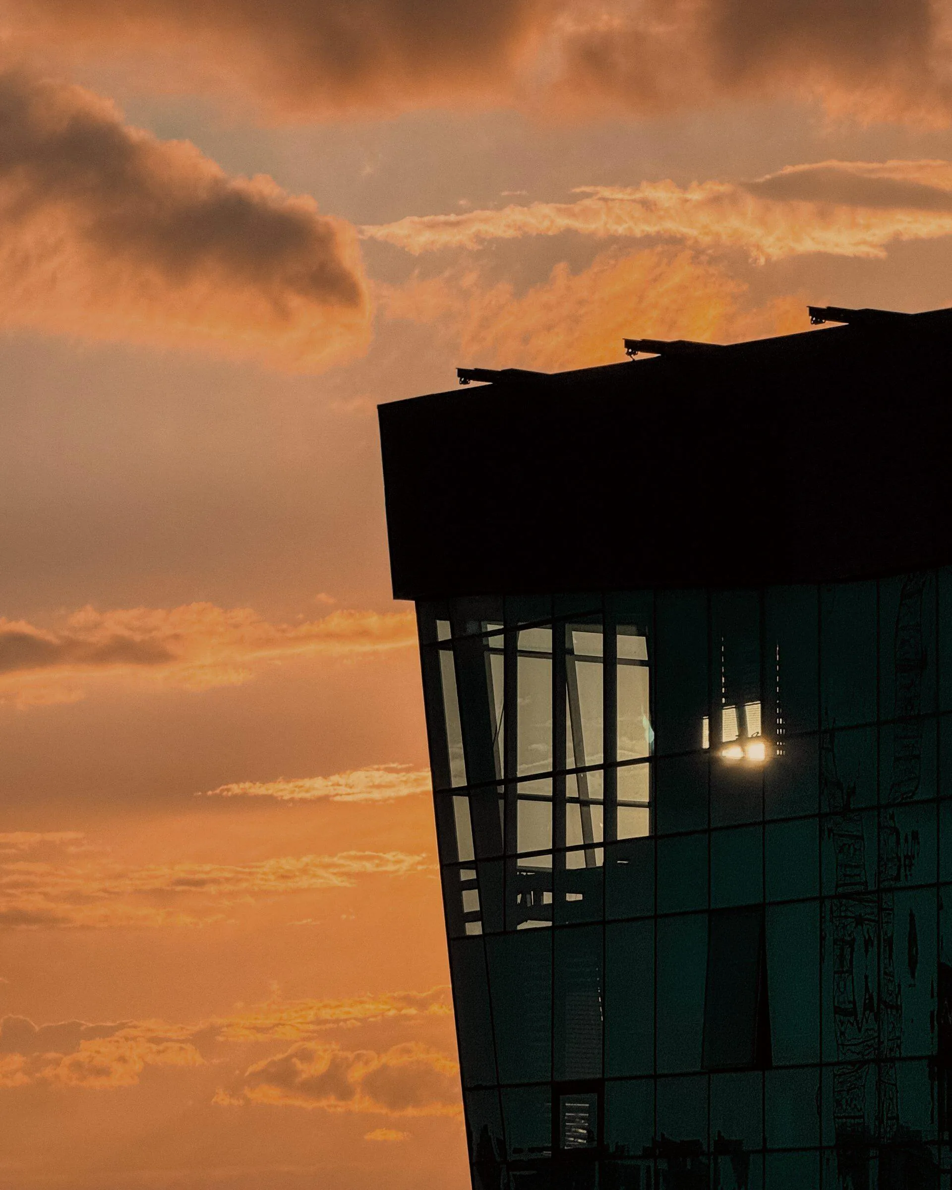 A modern glass office building at golden hour