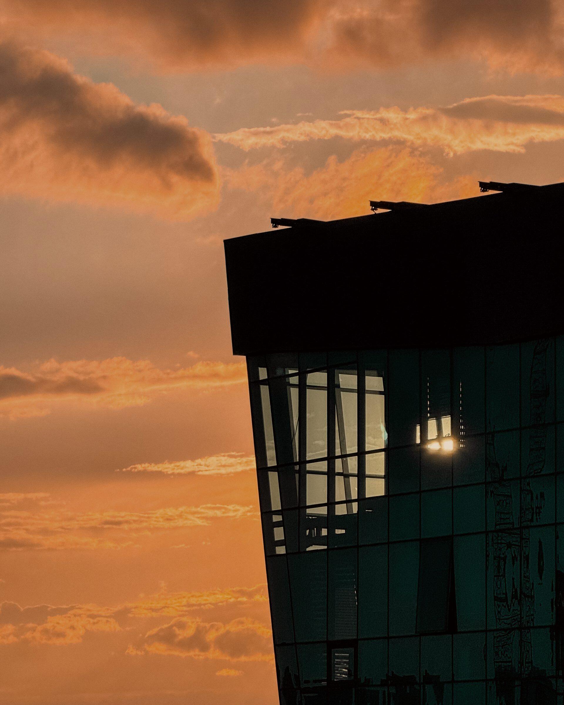 A modern glass office building at golden hour